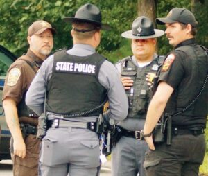 Long Morning Officers from multiple jurisdictions converged Saturday morning at intersection of Rts. 153 and 460 East. Among those shown in left photo are Nottoway Sgt. Ty Moore and Blackstone officer Dylan Mosier. Photo at right shows red truck driven by suspect who, according to police, was armed and exchanged gunfire with police before being killed by a Trooper.