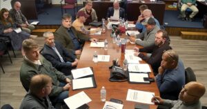Hard At Work In Pit Row Officials from Nottoway County and the towns of Blackstone, Burkeville, and Crewe met last Monday, Dec. 29th with representatives of the Ward Burton Wildlife Foundation, including founder Ward Burton (third at left side of table). Supervisors agreed to sell the Foundation 183 acres of County-owned land along Darvills Road (Rt. 40) near Fort Pickett for $2,013,000. That move follows the Board’s 5-0 vote on Dec. 18th to sell the Pickett Officer’s Club for $240,000. Supervisors are also proposing to sell old barracks in the LRA and 55 acres for $700,000. Burton is a South Boston native who won NASCAR’s Daytona 500 in 2002. Seated to Burton’s left is his Foundation’s Executive Director, Tom Inge.