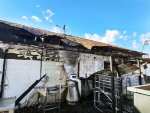 Started At Rear Of Store These photos on Blackstone Vol. Fire Department’s Facebook page show Spainville Store before units arrived on scene (upper left) and during firefighting operations (upper right). Bottom photos show store’s rear exterior, where, firefighters say, a nearby dumpster caught fire and flames spread to the rear awning and roof.