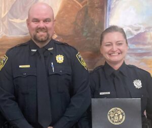 Happier Times Shooting victim Heather Burrow (right) is shown here in June 2023 after completing law enforcement academy. Among those congratulating her was Kenbridge Chief of Police Christopher Wallace (left). Ms. Burrow, who was shot and wounded several times on Feb. 8th -- allegedly by officer Aaron Stokes -- is now suing the Town and Chief Wallace for $143.7 million. Town of Kenbridge Facebook page